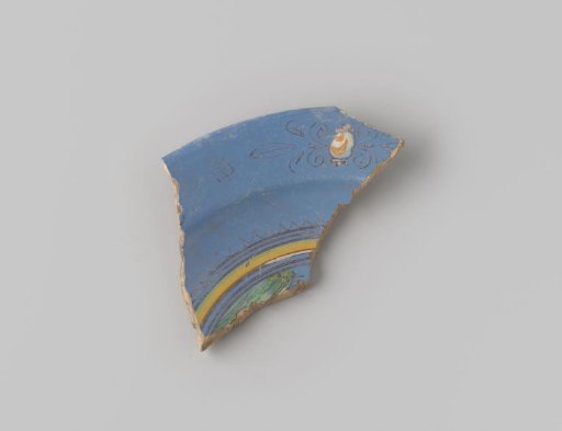 Fragment of reddish-fired earthenware, glazed blue on the upper side, decorated with a painting of a rhombus, stylized flower forms and a part of a circle in yellow, brown, orange and white