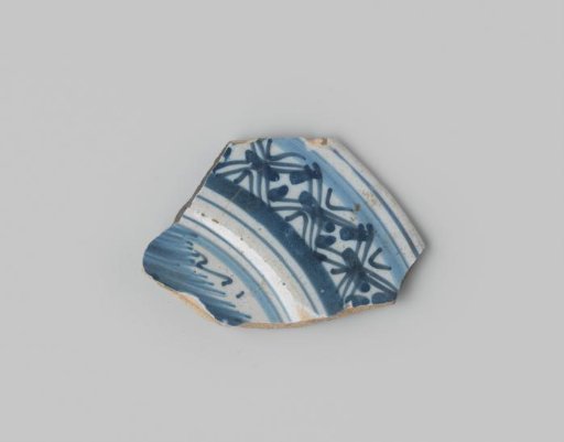 Sherd of reddish-firing earthenware, glazed white, with a border in blue on the front