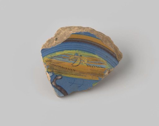 Fragment of reddish-fired earthenware, glazed blue on the upper side, painted with a representation of a ground with green and yellow vegetation, on which two brown-white legs of an animal are visible, the whole encircled with lines in brown, yellow and blue