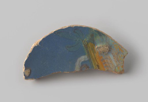 Fragment of reddish-fired earthenware, glazed blue on the upper side, with a portion of an unknown representation visible in blue, green, yellow, orange and white