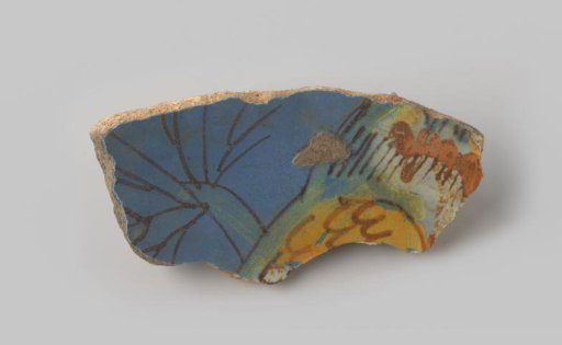 Fragment of reddish-fired earthenware, glazed blue on the upper side, with a portion of an unknown representation visible in blue, green, yellow, orange and brown