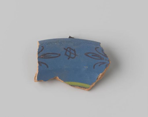 Fragment of reddish-fired earthenware, glazed blue on the upper side, with a diamond and stylized floral forms painted in brown, and a yellow stripe