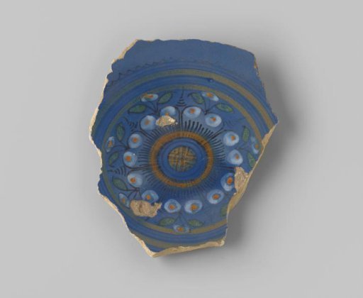 Sherd of yellowish-firing earthenware, glazed blue on the front with a floral motif in yellow, white, black, green and orange, and lead-glazed on the back
