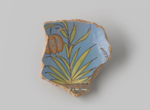 Fragment of reddish-fired earthenware, glazed blue on the front, with a painting of a tulip standing in the earth in brown, green, yellow and orange