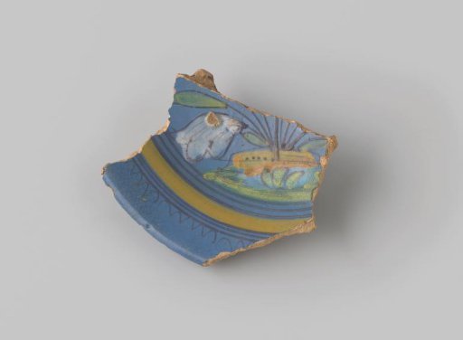 Fragment of reddish-fired earthenware, glazed blue on the front, with a painted flower in the earth, and around it stripes and a wavy rim in brown and yellow