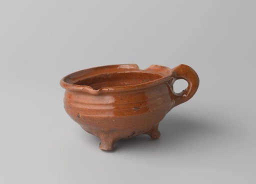 Cooking pot of red-baking earthenware, on three legs, with a handle, lined with lead glaze inside, rim damaged
