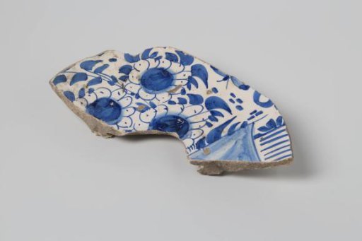 Sherd of earthenware with lead glaze on the reverse and tin glaze on the obverse, decorated with flowers in blue, damaged