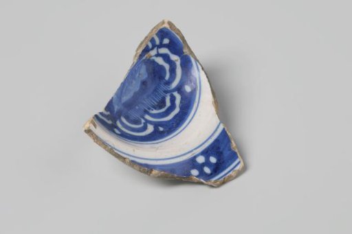 Sherd of a bowl of earthenware with white tin glaze on the inside and outside and a decoration in blue, damaged