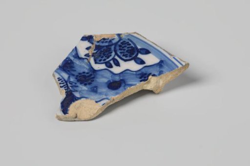 Sherd of a plate of earthenware with white tin glaze on the underside and white tin glaze on the upper side and a decoration in blue, damaged