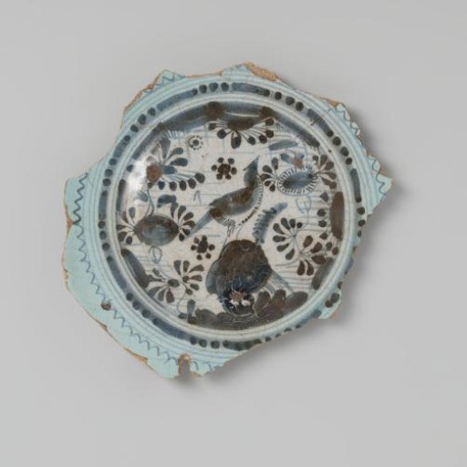 Sherd of earthenware, with lead glaze on the underside and white tin glaze on the upper side, depicting flowers and a bird in blue, damaged