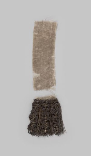 Fringe of silver thread decorated with three garlands of loops alternating with cartouches in the form of four-leaf rosettes, at the end of a silk taffeta ribbon (torn)