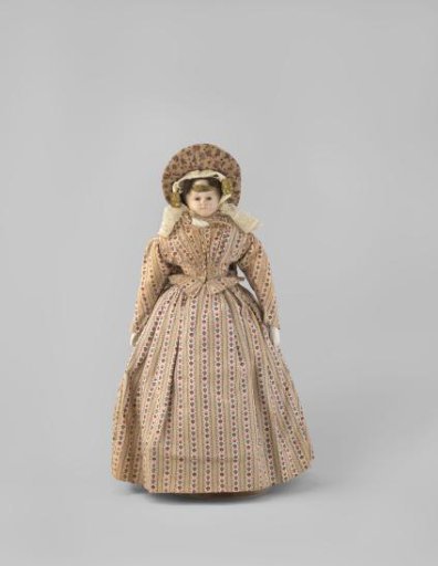 Doll in Regional Costume. Straw Canopy Hat, Lace Cap and Ear Protectors. Skirt and Bodice of Printed Cotton, Black Wool Apron, Purple Cotton Cape and Black Woolen Cape