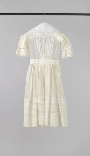 Dress with short sleeves, wide waistband, and back closure with two mother-of-pearl buttons of transparent woven white cotton, decorated with smocking, English embroidery, and lace.
