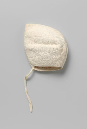 Child's cap of white cotton with Zaan embroidery, constructed from six bands and with one ribbon tie