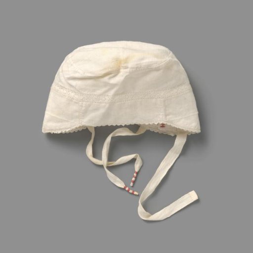Children's cap of white linen, decorated with an openwork edge, a canter edge and initials TA in red cross-stitch; three ribbons, two wrapped with red thread