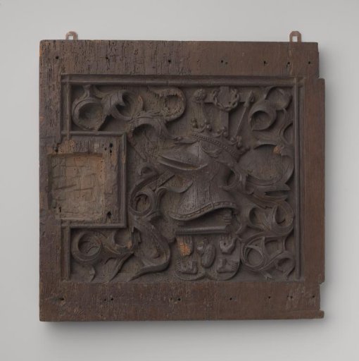 Door decorated with deeply carved, partially openwork ornament featuring a coat of arms incorporating the instruments of Christ's Passion