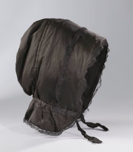 Hood or calèche (Thérèse) of quilted black taffeta, originally supported by three (one missing) whalebones, lined with black silk and trimmed with black lace