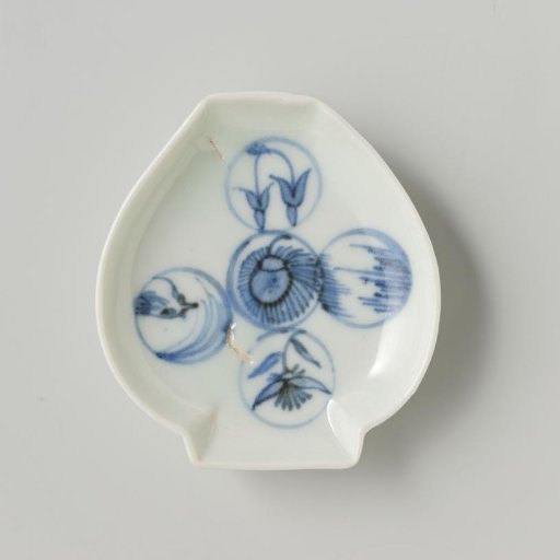 Porcelain dish in the form of a closed lotus flower (?). Blue underglaze decoration of five circles with Japanese man (flowers).