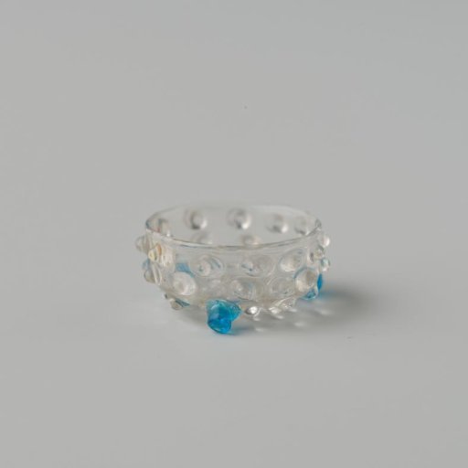 Bowl of clear colourless glass decorated with warts or knobs, standing on three blue ball feet.