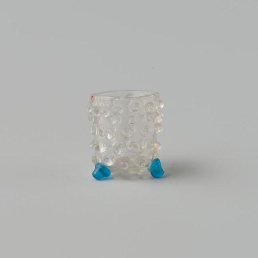 Goblet of clear colourless glass decorated with knobs standing on three ball feet.