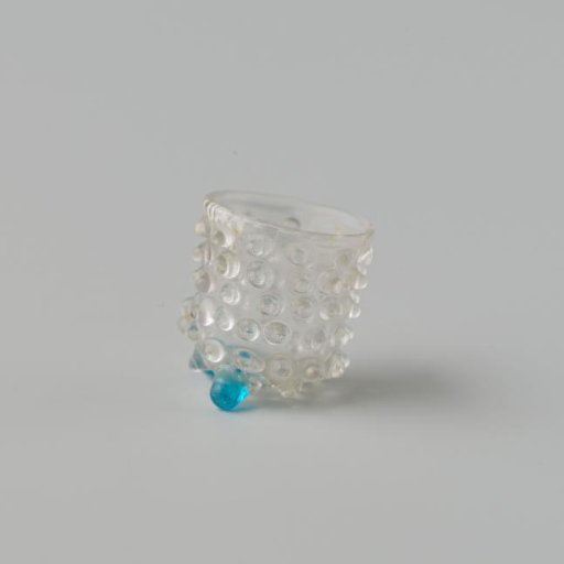 Goblet of clear colourless glass decorated with knobs standing on three ball feet.