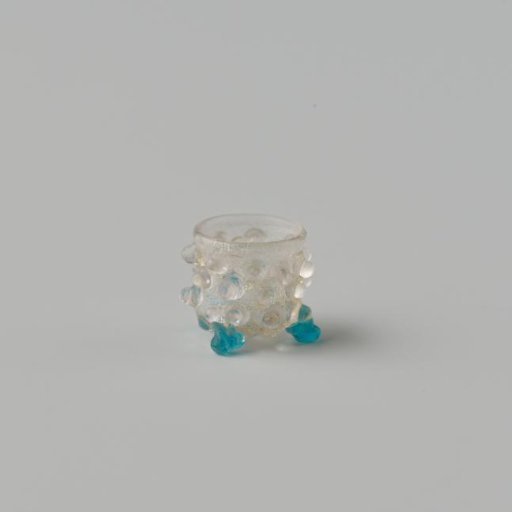 Goblet of clear colourless glass decorated with knobs standing on three ball feet.