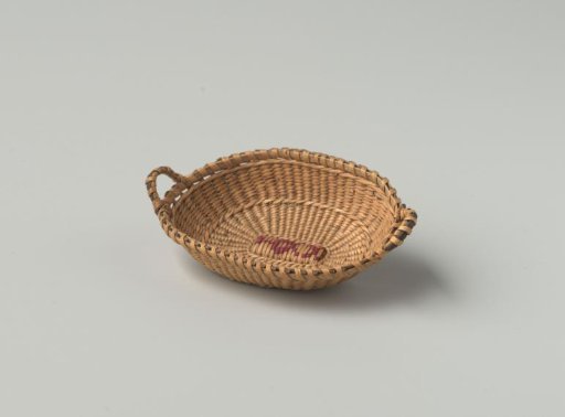 Low oval basket of split willow, fine wickerwork, with two handles, reinforced with dark horsehair (?); base embroidered with a floral motif in red silk.