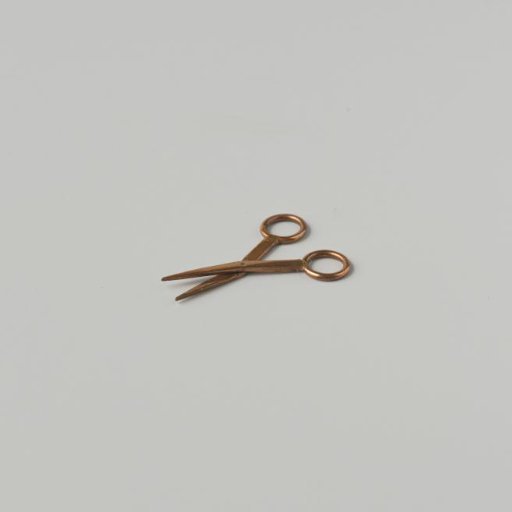 Scissors of red copper with ring-shaped handles, and hinged around a rivet