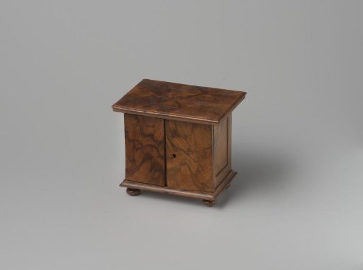 Chest of drawers made of walnut and oak; resting on four ball feet