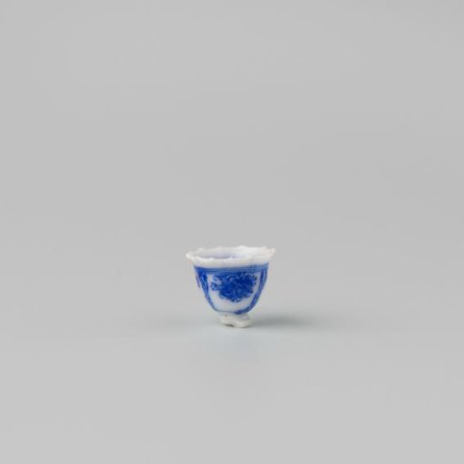 Milk glass teacup with blue enamel painting, imitation Chinese porcelain with 'flower' decoration in panels; model on a separately attached foot ring with a pointed rim.