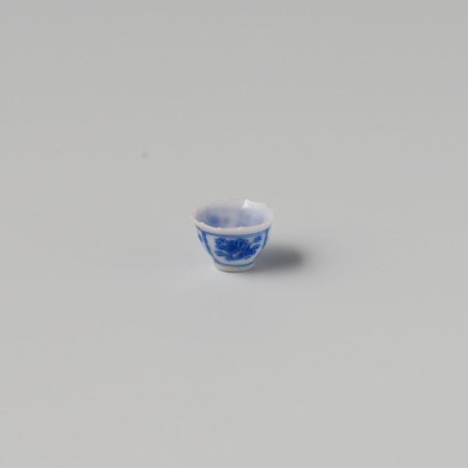 Milk-glass teacup with blue enamel painting, imitation Chinese porcelain with 'flower' decoration in three compartments; model with a pointed rim, barely a foot ring.