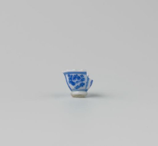 Milk-glass teacup with blue enamel painting, imitation Chinese porcelain with 'flower' decoration in three compartments; model with a pointed rim, barely a foot ring.
