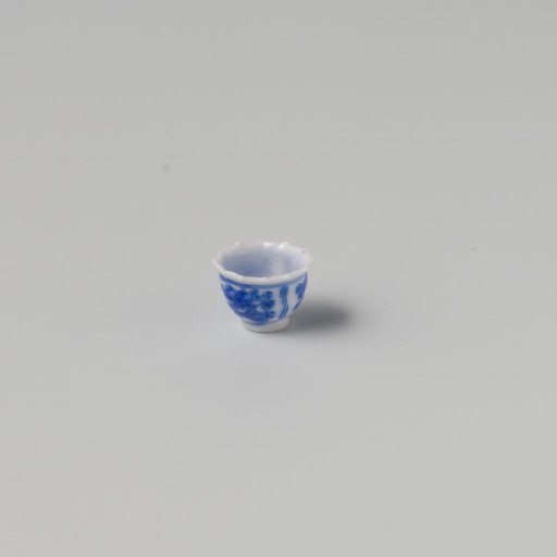Milk-glass teacup with blue enamel painting, imitation Chinese porcelain with 'flower' decoration in three compartments; model with a pointed rim, barely a foot ring.