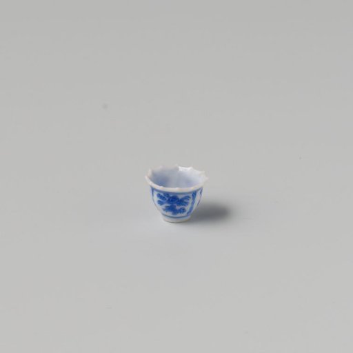 Milk-glass teacup with blue enamel painting, imitation Chinese porcelain with 'flower' decoration in three compartments; model with a pointed rim, barely a foot ring.