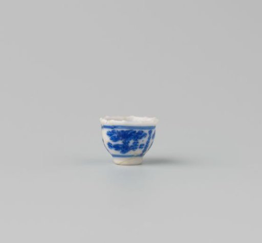 Milk-glass teacup with blue enamel painting, imitation Chinese porcelain with 'flower' decoration in three compartments; model with a pointed rim, barely a foot ring.