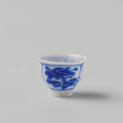 Milk-glass teacup with blue enamel painting, imitation Chinese porcelain with 'flower' decoration in compartments; on a foot ring with a smooth rim.
