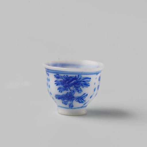 Milk-glass teacup with blue enamel painting, imitation Chinese porcelain with 'flower' decoration in compartments; on a foot ring with a smooth rim.