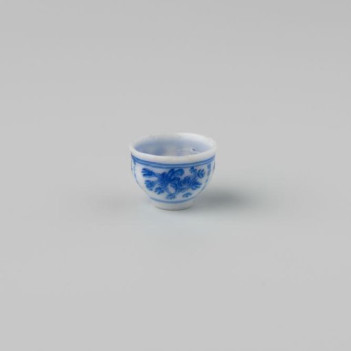 Milk-glass teacup with blue enamel painting, imitation Chinese porcelain with 'flower' decoration in panels; on a stand ring and with a smooth rim.