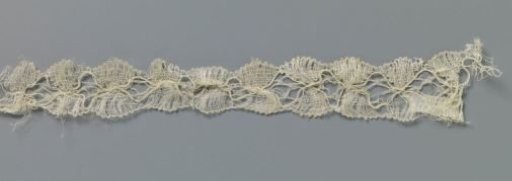 Strip of bobbin lace with diamond-shaped field between mirrored fans