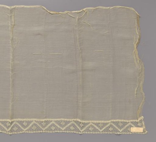 Batiste voile with one border of bobbin lace with zigzag line and four-leaf clover
