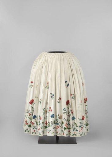 Unlined skirt with side slits of white ribbed cotton, multicoloured in wool tamboured (?) with flower and leaf scrolls and loose flower and leaf branches