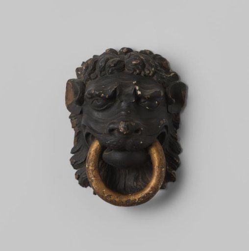 Door knocker in the form of a lion's head of wood with a gilded ring in its mouth