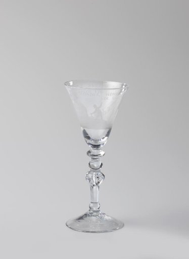 Chalice glass with a ship with women and the inscription: O WONDER WONDER AND ONCE AGAIN WONDER THE SHIP IS FULL OF HOLES AND DOES NOT SINK