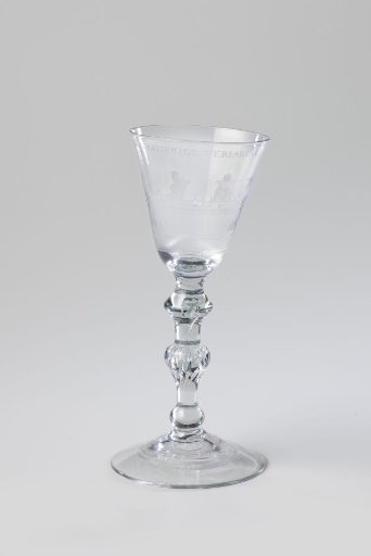 Chalice glass with a company at table and the inscription: THE HAPPY ARRIVAL