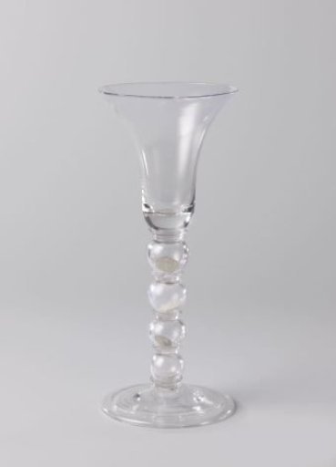 Chalice glass with four enclosed English coins (penny, two pence, three pence, and four pence)