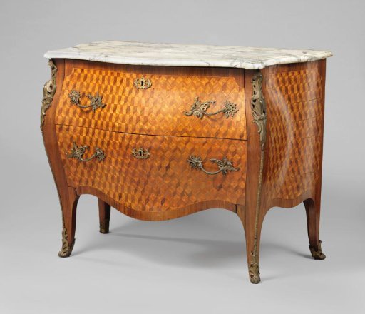 Commode, decorated with marquetry and with a curved front with two drawers, between two stretched S-shaped corner legs. Mounts with rocaille motifs