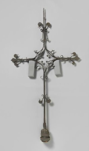 Tower cross whose intersection is forged into a rhombus with four leaves. The arms end in lilies.