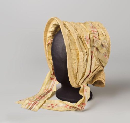 Canopy hat in one piece, of yellow taffeta decorated with a yellow/red/beige colored satin ribbon, which is to be tied under the chin