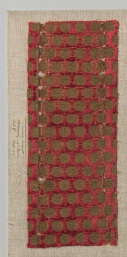 Fragment of red velvet with circles in gold thread