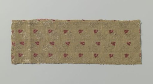 Fragment of yellow silk with a leaf motif in yellow and red